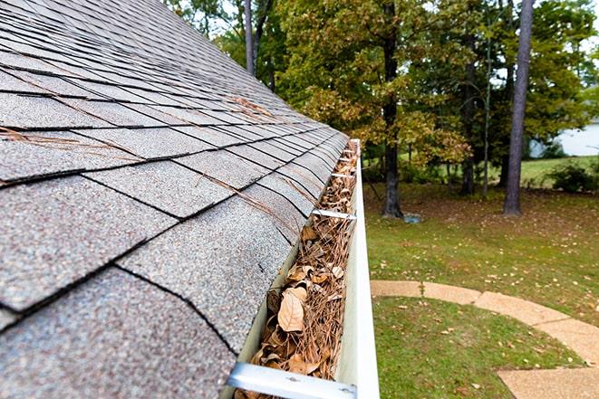 rain gutter with leaves and debris being removed